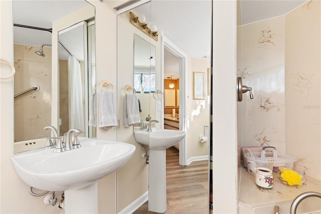 bathroom featuring dual sinks and wood-type flooring