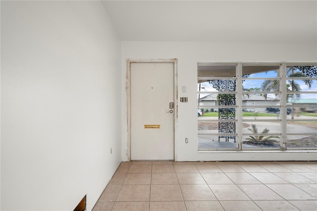 doorway to outside with light tile patterned floors