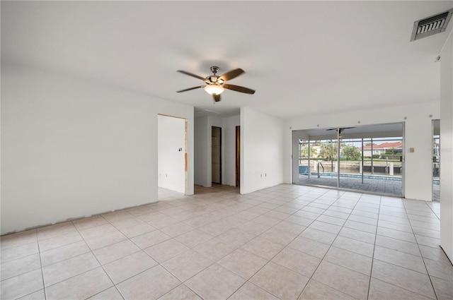 tiled empty room featuring ceiling fan