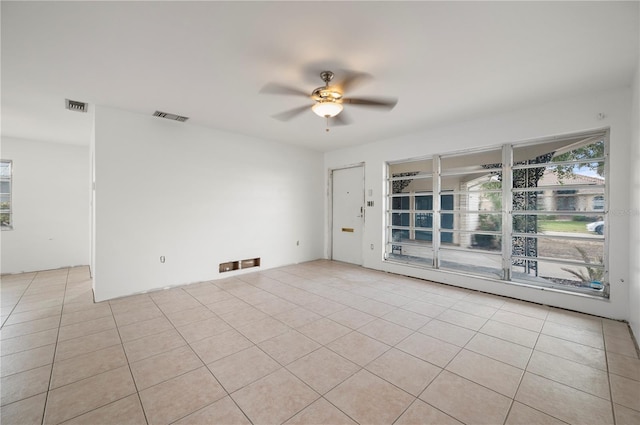 tiled spare room with ceiling fan