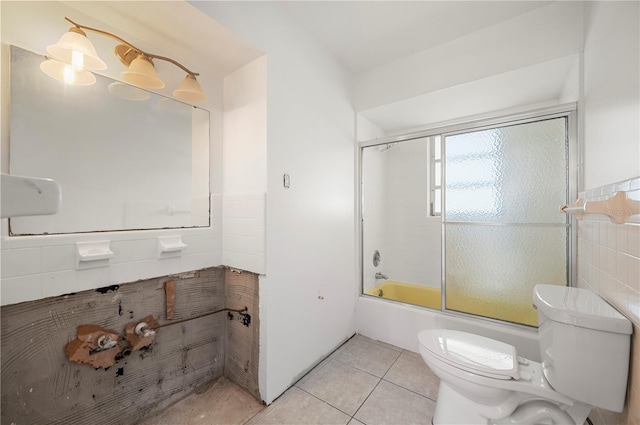 bathroom featuring bath / shower combo with glass door, toilet, and tile patterned flooring