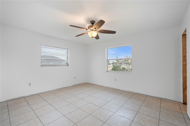 empty room with ceiling fan and light tile patterned flooring