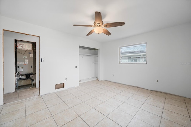 unfurnished bedroom with ceiling fan, light tile patterned floors, and a closet