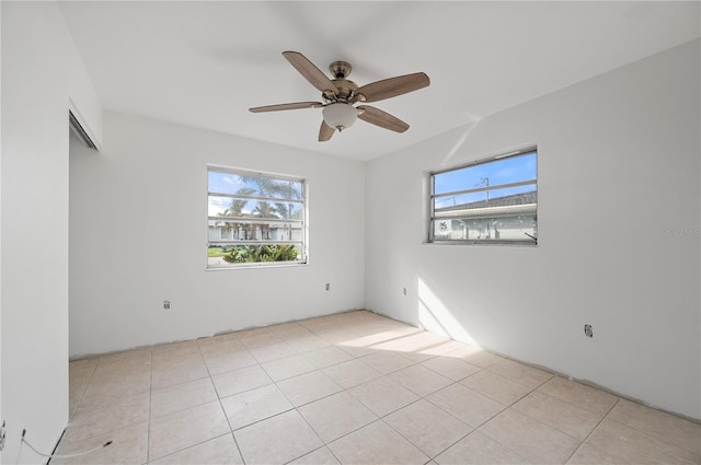 tiled spare room featuring ceiling fan