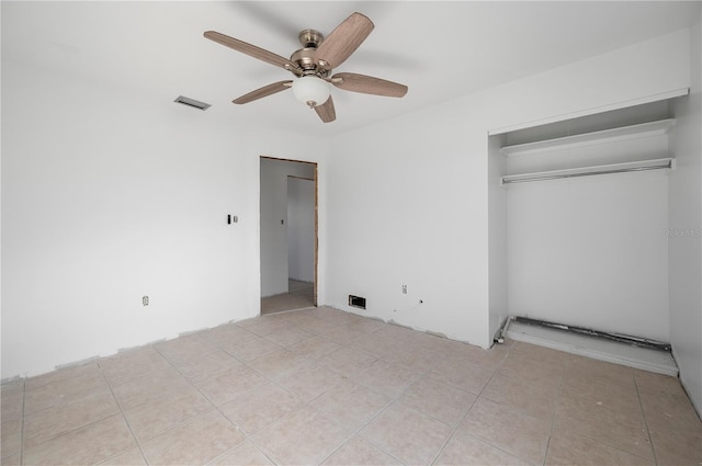 unfurnished bedroom with ceiling fan, light tile patterned floors, and a closet