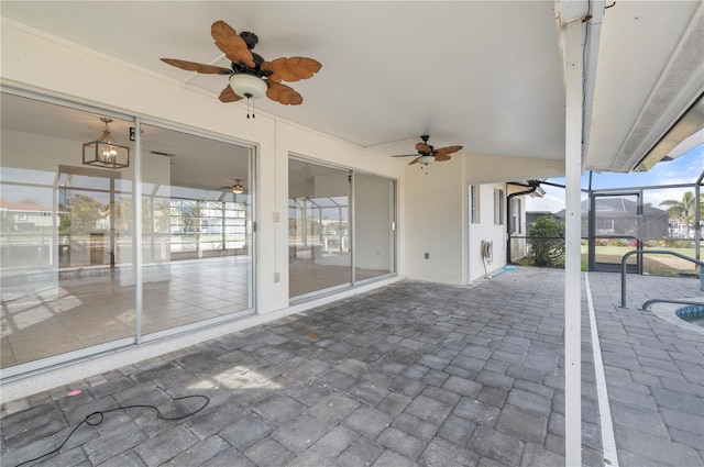 view of patio featuring ceiling fan and glass enclosure