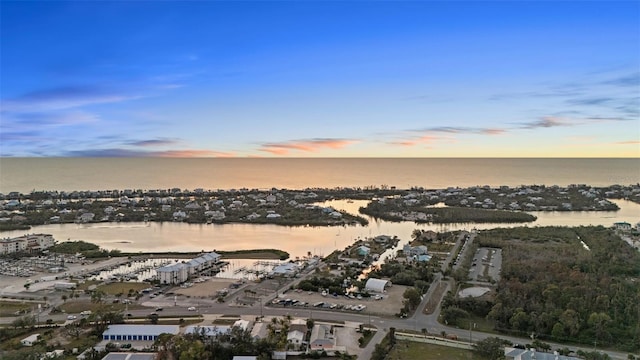 aerial view at dusk featuring a water view