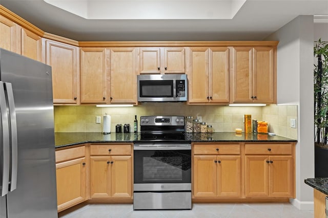 kitchen with appliances with stainless steel finishes, backsplash, dark stone counters, light tile patterned floors, and light brown cabinets