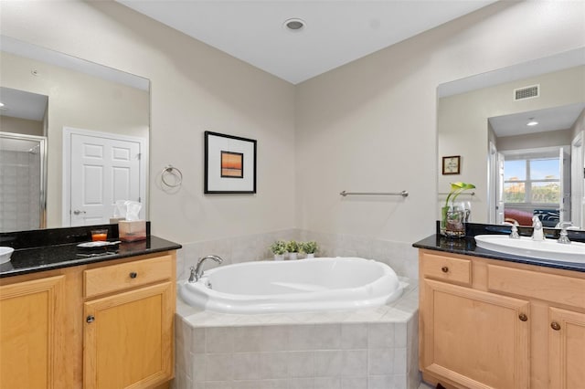 bathroom featuring vanity and independent shower and bath