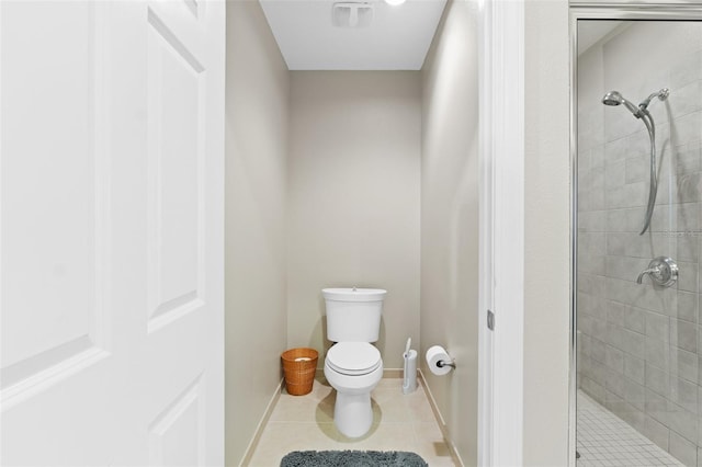 bathroom with tile patterned floors, toilet, and a shower with shower door