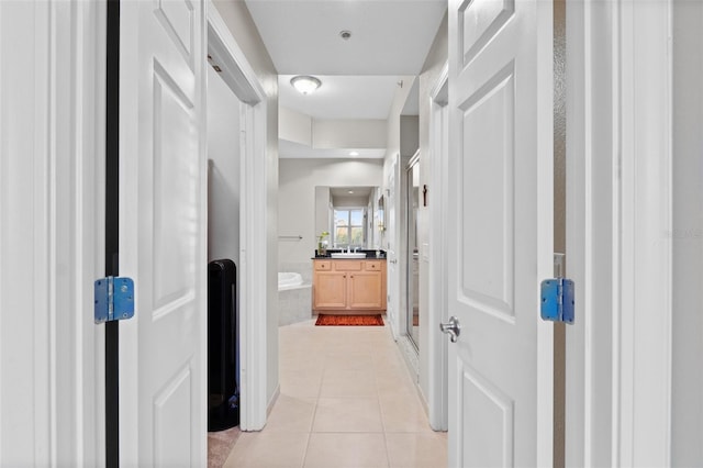 corridor featuring light tile patterned flooring and sink