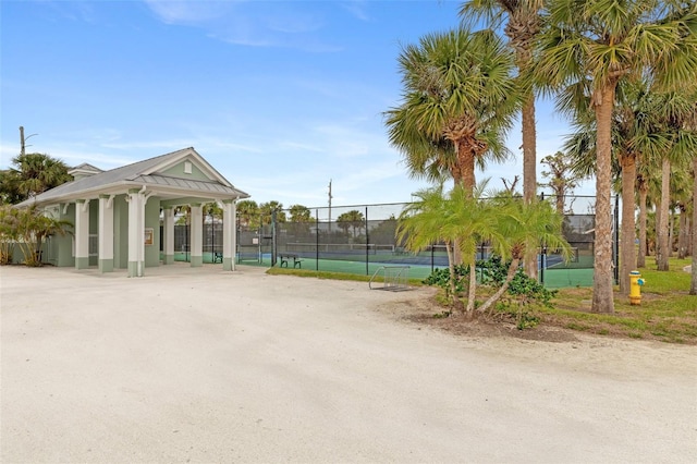 view of community featuring tennis court