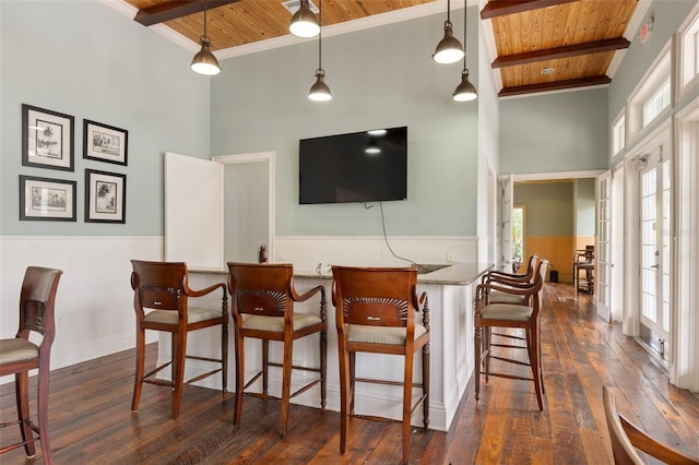 bar featuring dark hardwood / wood-style floors, pendant lighting, wooden ceiling, and beam ceiling