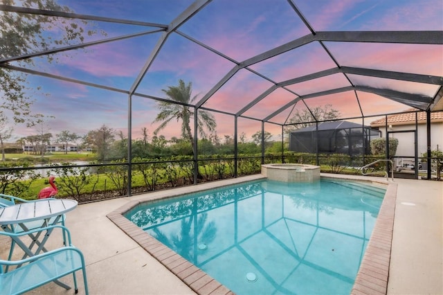 pool at dusk featuring a lanai, a patio area, and an in ground hot tub