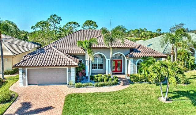 mediterranean / spanish home with a front lawn and a garage