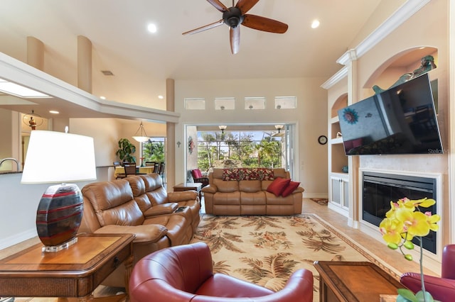 living room with ceiling fan, built in shelves, and crown molding