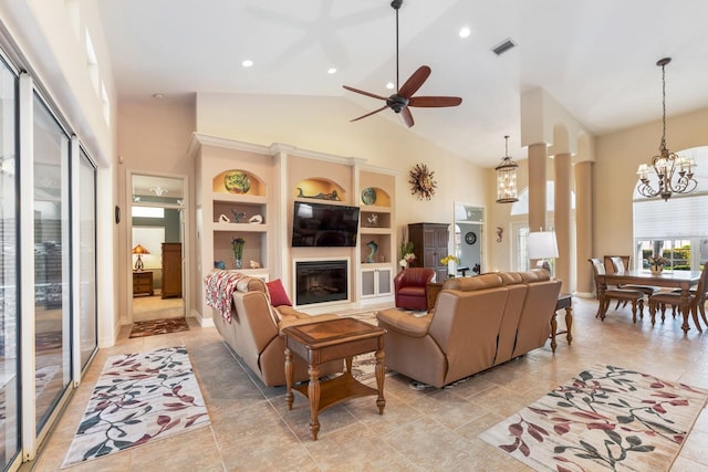 living room featuring ceiling fan with notable chandelier, high vaulted ceiling, and built in shelves