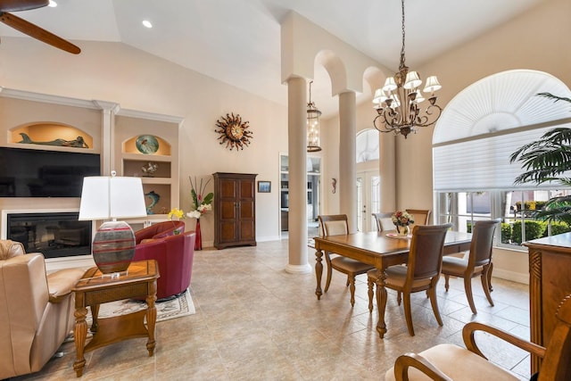 dining room with a chandelier, built in features, high vaulted ceiling, and decorative columns