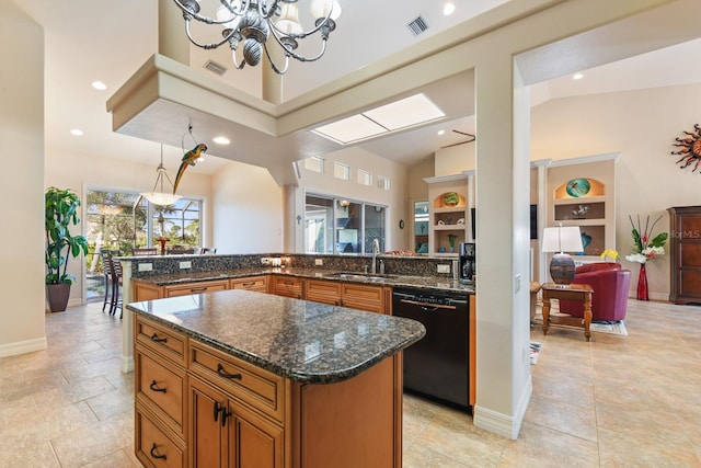 kitchen with black dishwasher, sink, hanging light fixtures, dark stone counters, and a center island