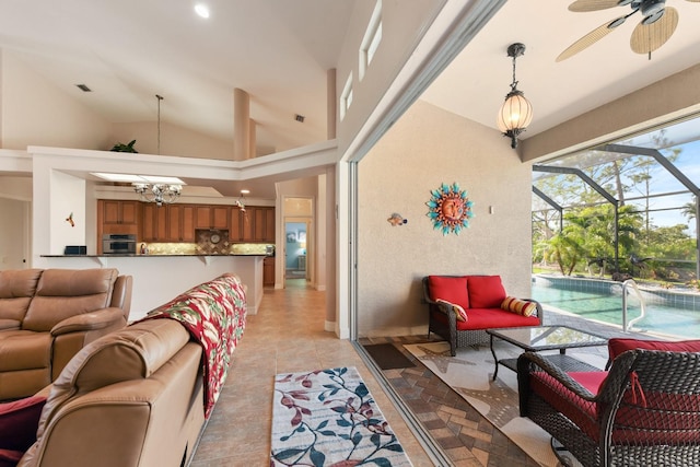 living room featuring ceiling fan, a high ceiling, and light tile patterned flooring