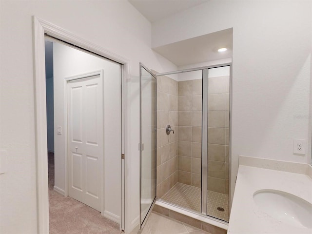 bathroom with a shower with shower door and sink