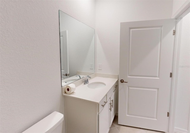 bathroom featuring toilet, tile patterned flooring, and vanity