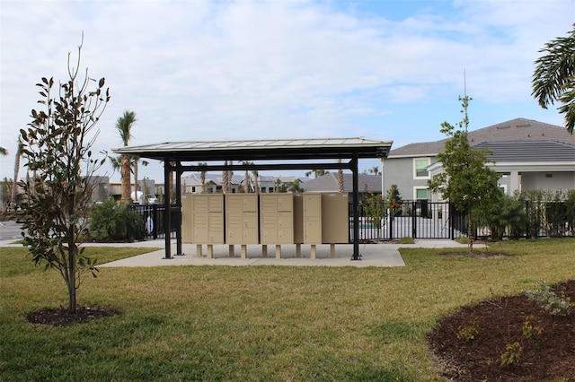 view of property's community featuring mail boxes and a yard