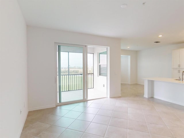 unfurnished room with sink and light tile patterned floors