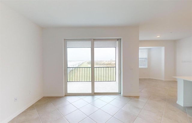 spare room with a wealth of natural light and light tile patterned floors