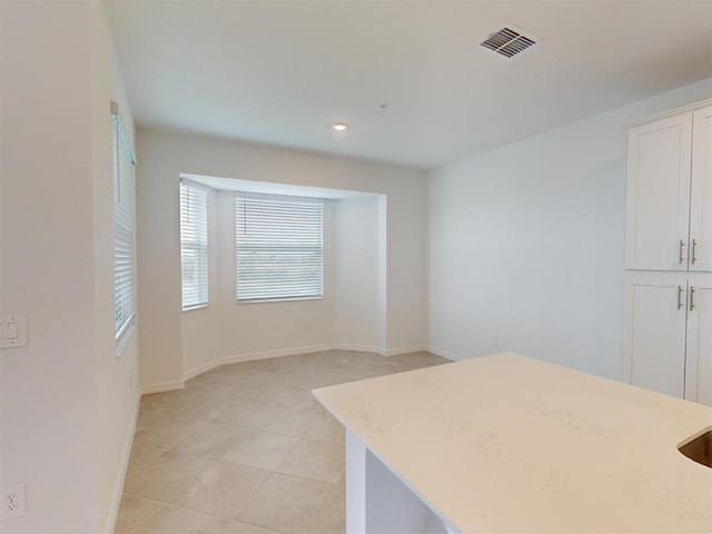 kitchen with white cabinetry and light tile patterned floors