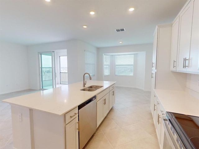 kitchen featuring white cabinets, stainless steel appliances, an island with sink, sink, and light tile patterned floors