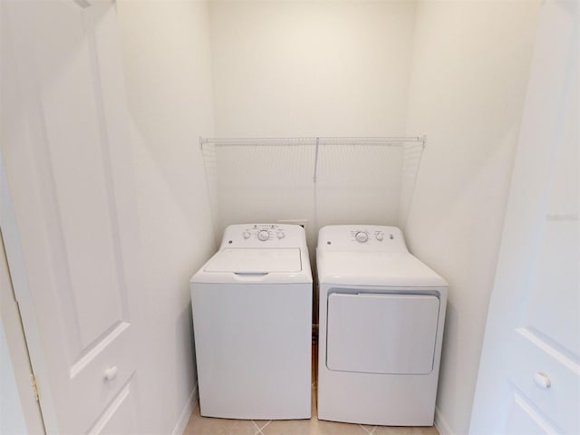 laundry area with light tile patterned floors and washer and clothes dryer