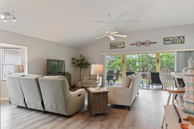 living room with ceiling fan, vaulted ceiling, and light hardwood / wood-style flooring