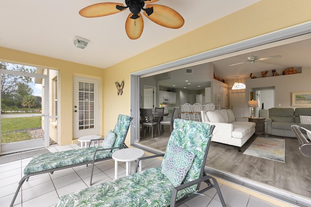 sunroom / solarium with ceiling fan and lofted ceiling