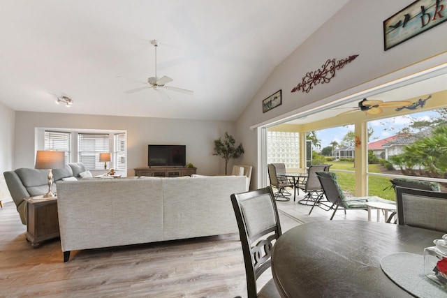 living room featuring ceiling fan, vaulted ceiling, and light hardwood / wood-style floors