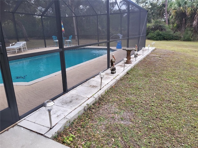 view of pool with a lanai, a lawn, and a patio area