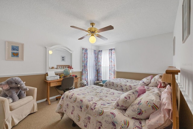 bedroom with ceiling fan, light carpet, and a textured ceiling