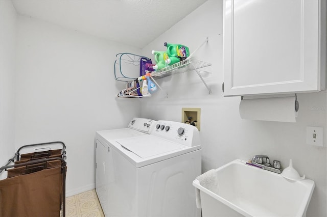 laundry room with cabinets, washer and dryer, and sink