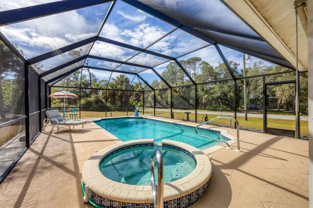 view of pool featuring an in ground hot tub, a lanai, and a patio