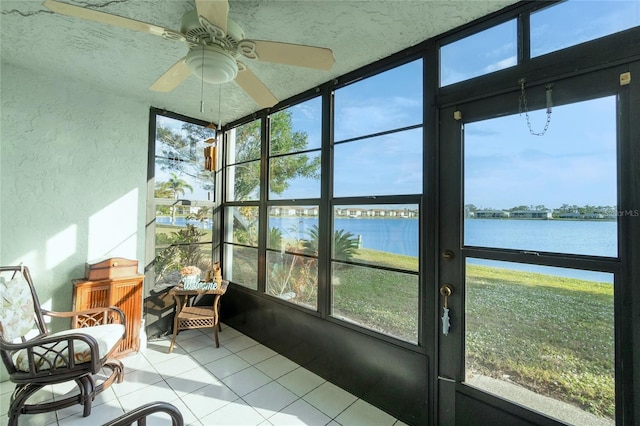 sunroom / solarium featuring ceiling fan and a water view