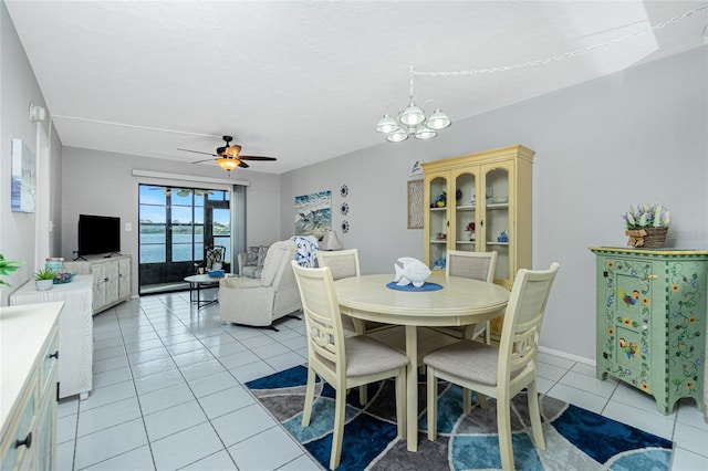 tiled dining space featuring ceiling fan with notable chandelier