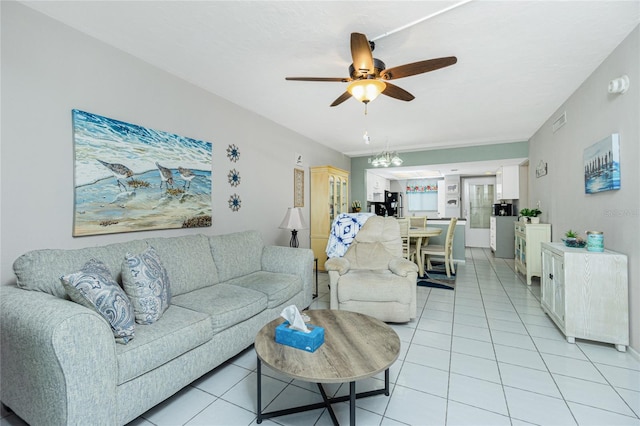 tiled living room with ceiling fan with notable chandelier