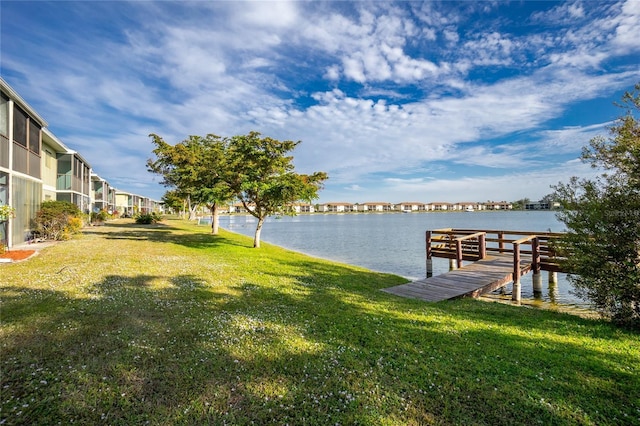 dock area with a water view and a yard