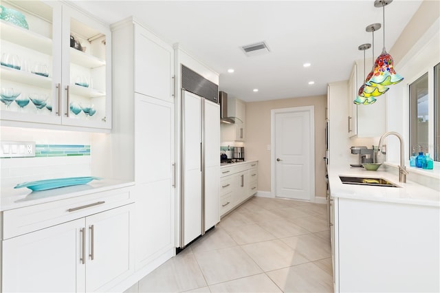 kitchen with pendant lighting, white cabinetry, paneled built in refrigerator, sink, and light tile patterned flooring