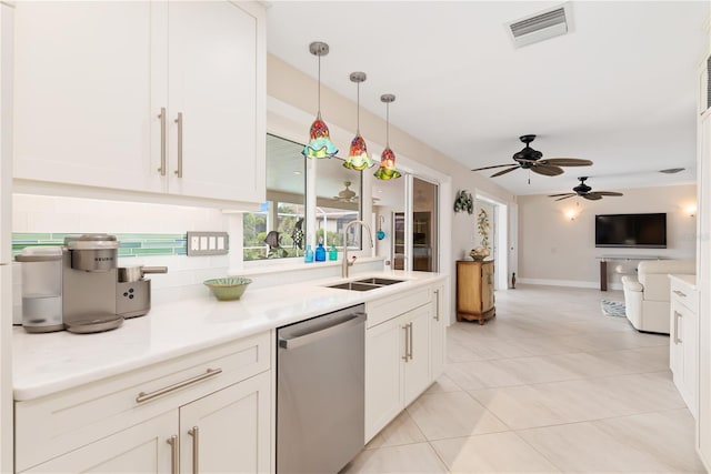 kitchen featuring stainless steel dishwasher, white cabinets, sink, and hanging light fixtures