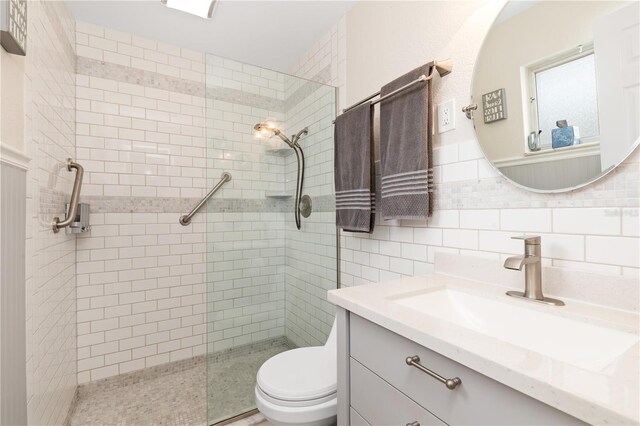 bathroom with backsplash, toilet, vanity, and an enclosed shower