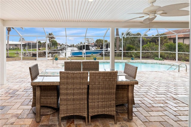 view of swimming pool featuring ceiling fan, glass enclosure, and a patio