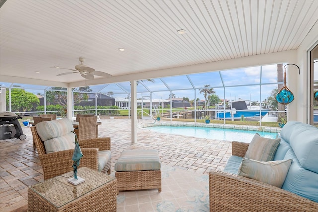 view of patio with an outdoor living space, glass enclosure, ceiling fan, pool water feature, and area for grilling