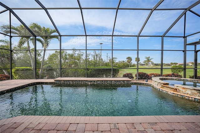 view of swimming pool featuring glass enclosure and an in ground hot tub