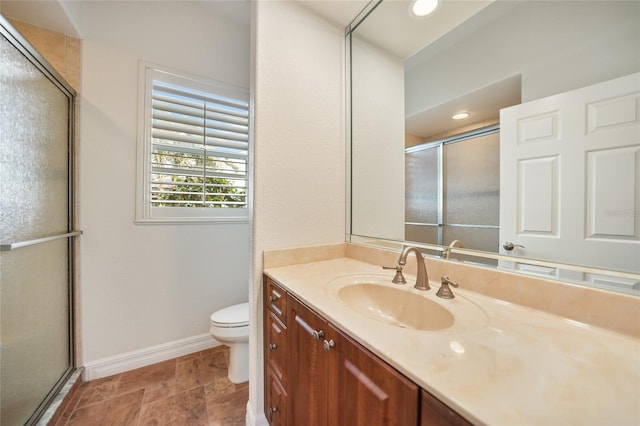 bathroom with toilet, a shower with door, and vanity